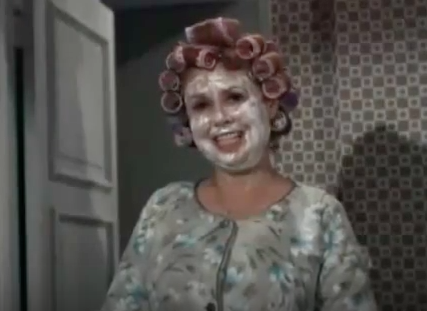 Mrs. Kravitz in curlers with cold cream on her face